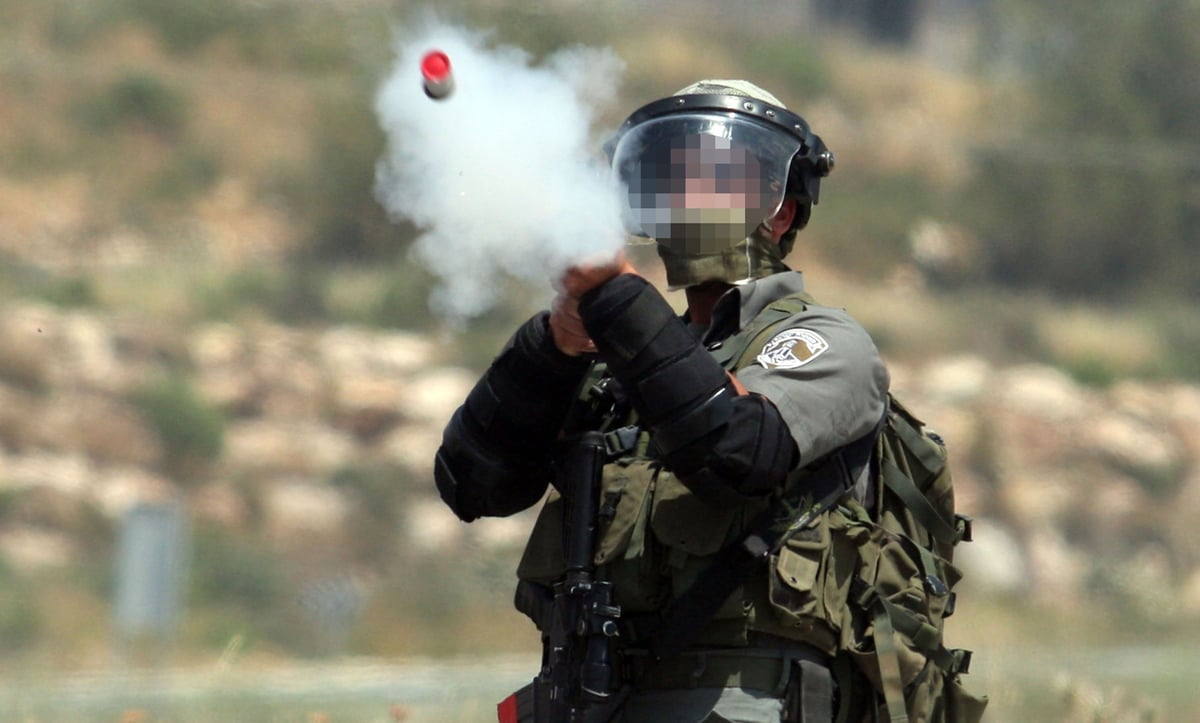 לוחם מג"ב יורה לעבר מפגינים פלסטינים