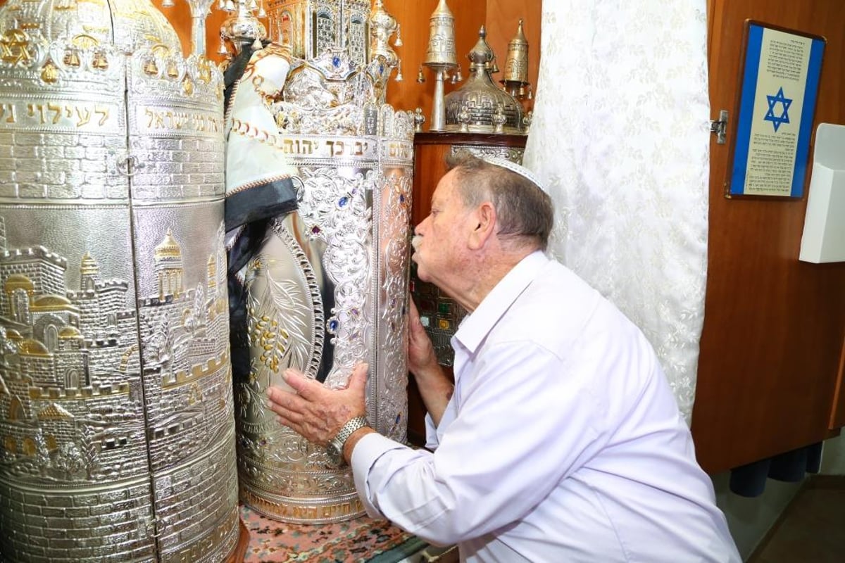 הזוכה מנשק את ספר התורה החדש