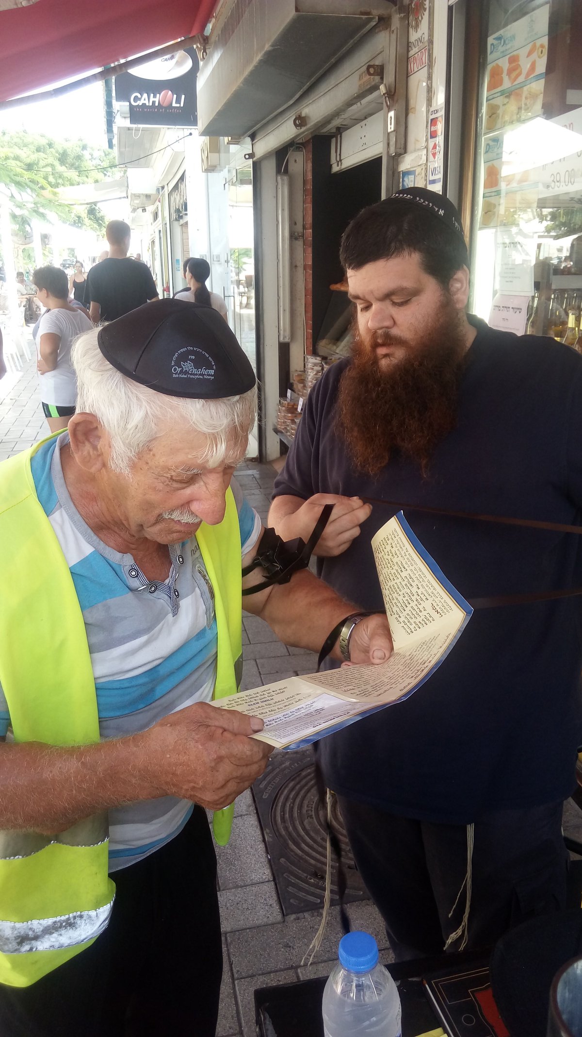 היהודי הישיש מניח תפילין עם הרב לאלום