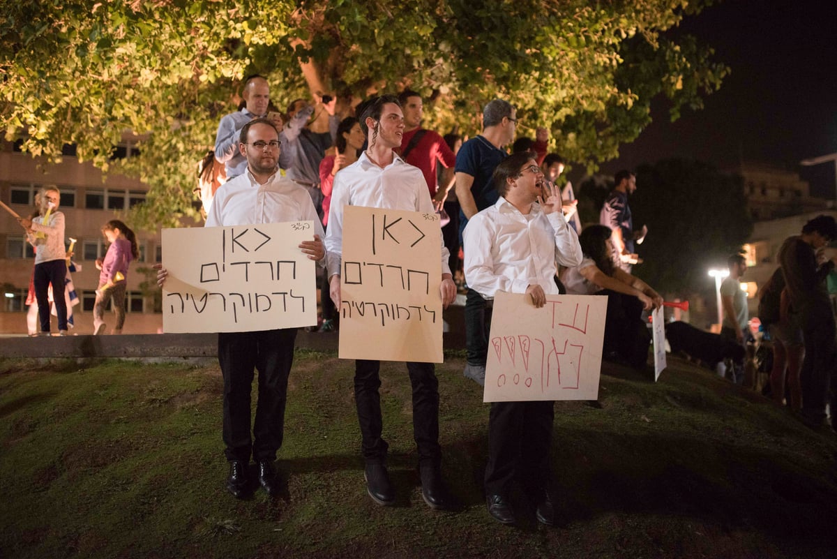 משמאל: עקיבא וייס מפגין