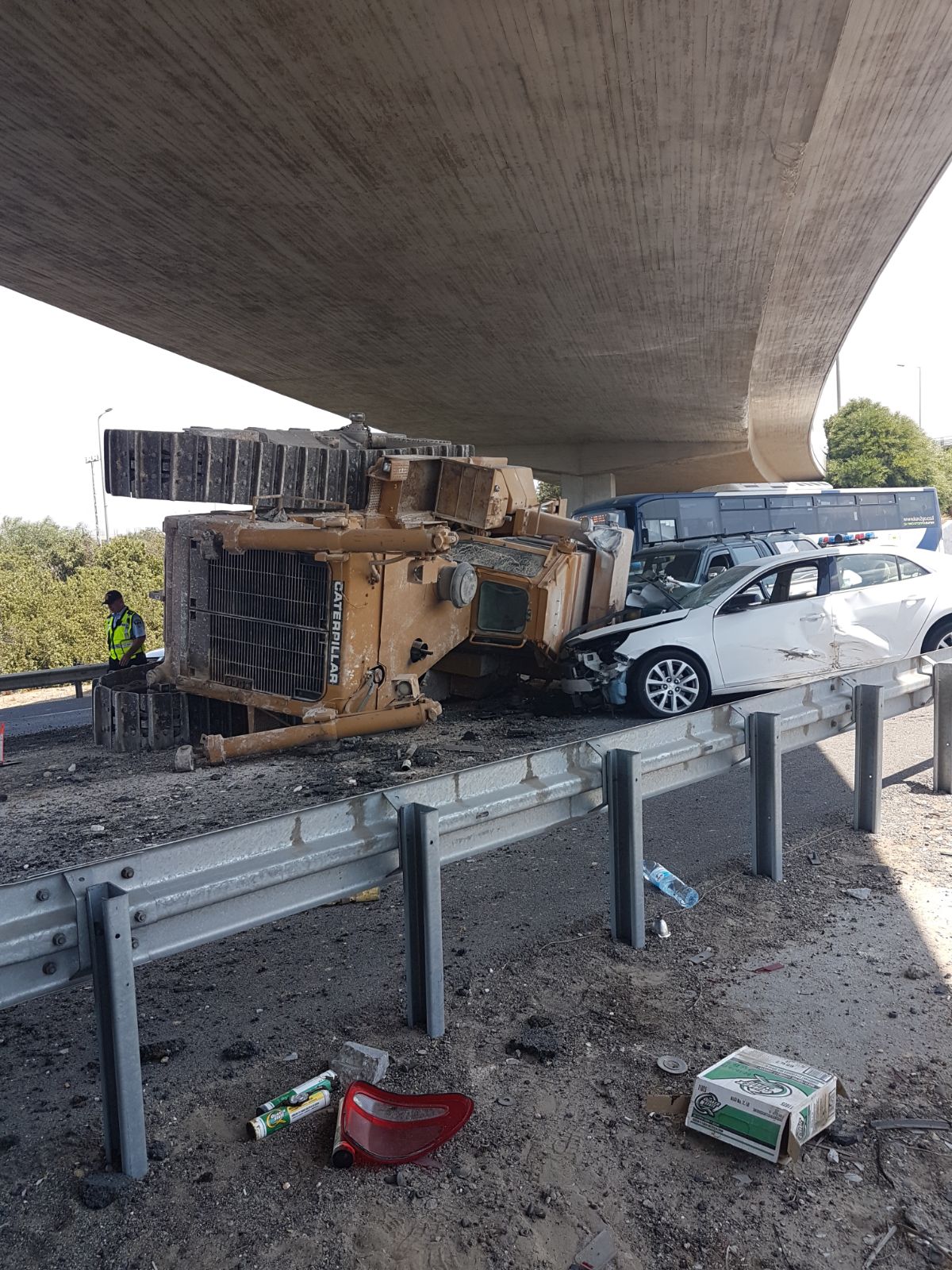 טרקטור פגע בגשר ונפל מהמשאית על רכב חולף