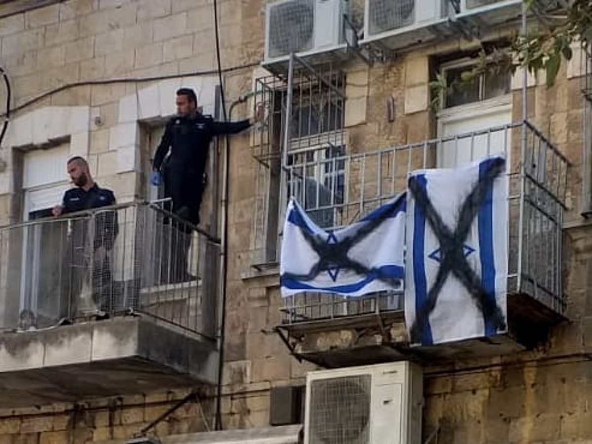 שוטרים קפצו מהמרפסת של השכן והסירו דגלים מרוססים