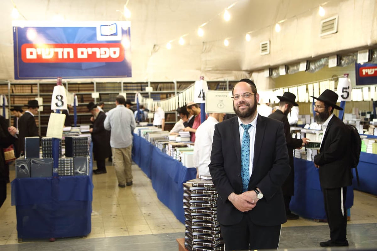 מנכ"ל המכון על רקע אולם התצוגה הענק והמרהיב שכולל אלפי ספרים מחולקים לפי קטגוריות