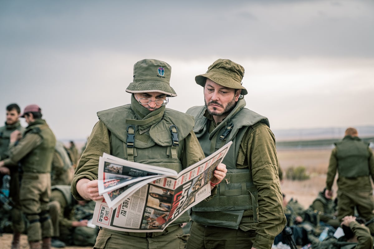 מילואימניקים קוראים בעיתון יום אחרי הטבח