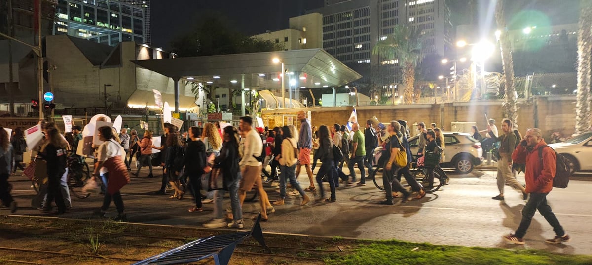 מפגינים צועדים ליד כיכר החטופים בתל אביב