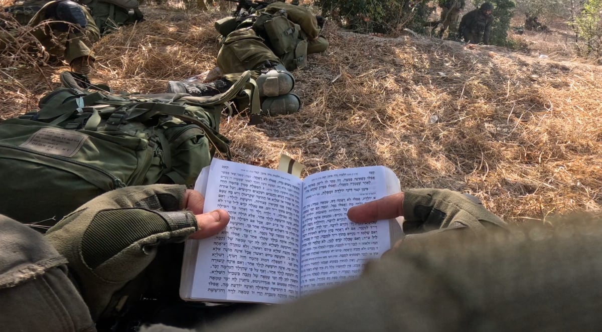 חייל לומד שולחן ערוך בהפוגת קרב
