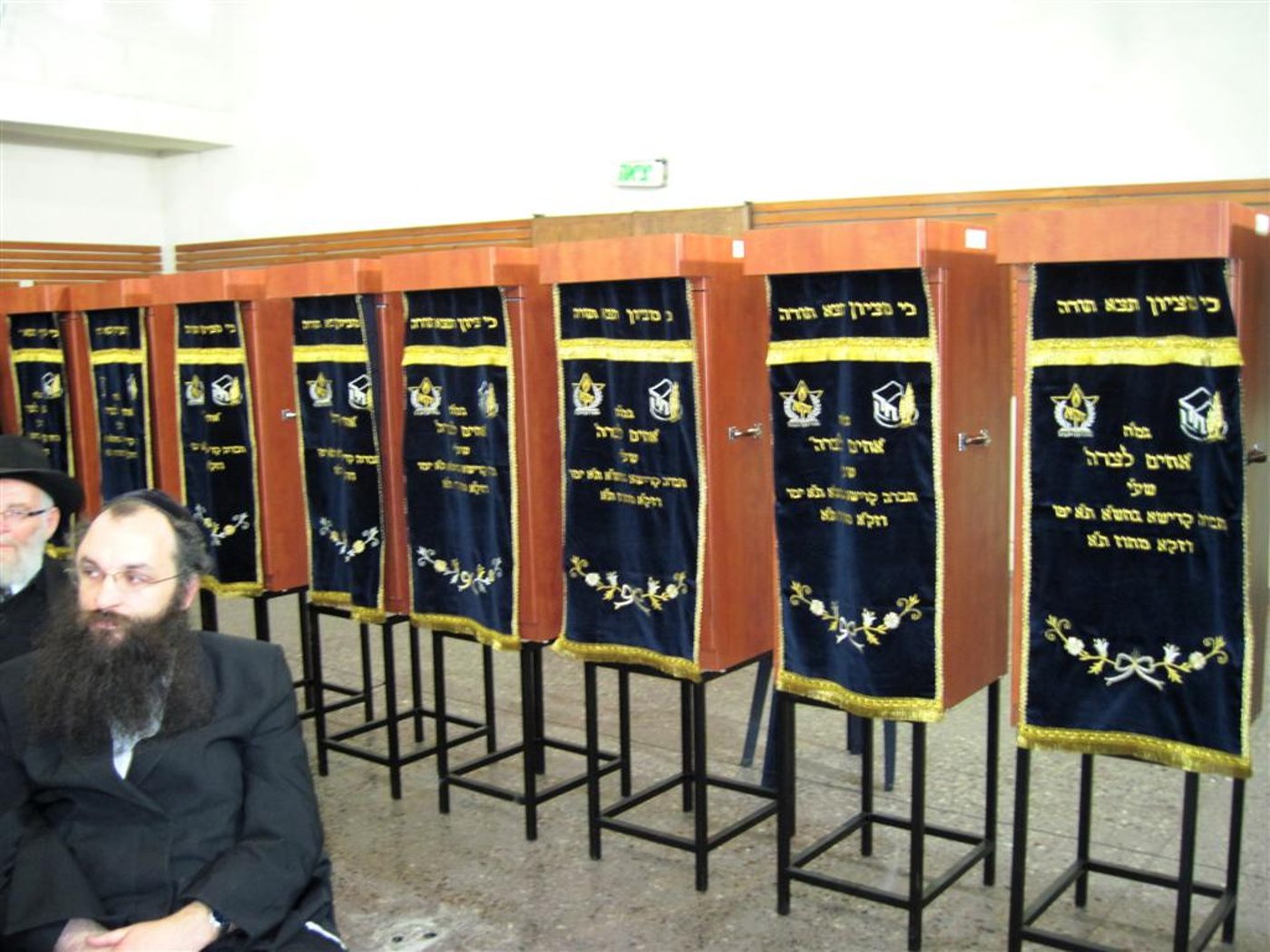 יוזם הגמ"ח, ר' צביקה חסיד על רקע ארונות הקודש
