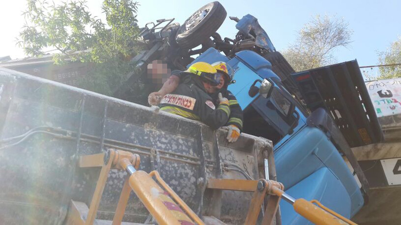 סיבוב מוצא: נהג המשאית התהפך ונשאר תלוי באוויר • תמונות