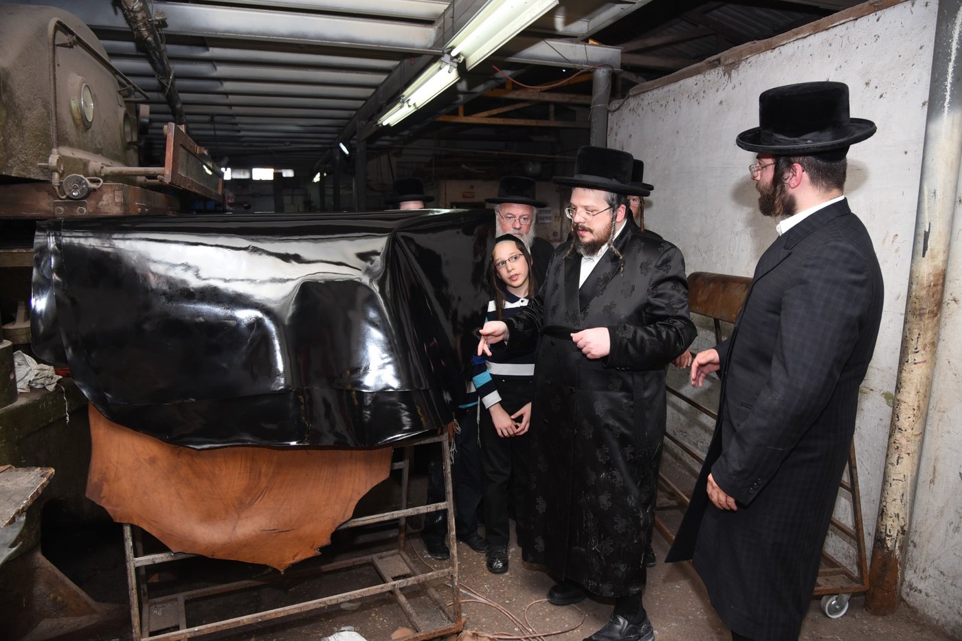 בן הרבי מבעלזא בהכנת רצועות ובתי תפילין לבנו • תיעוד