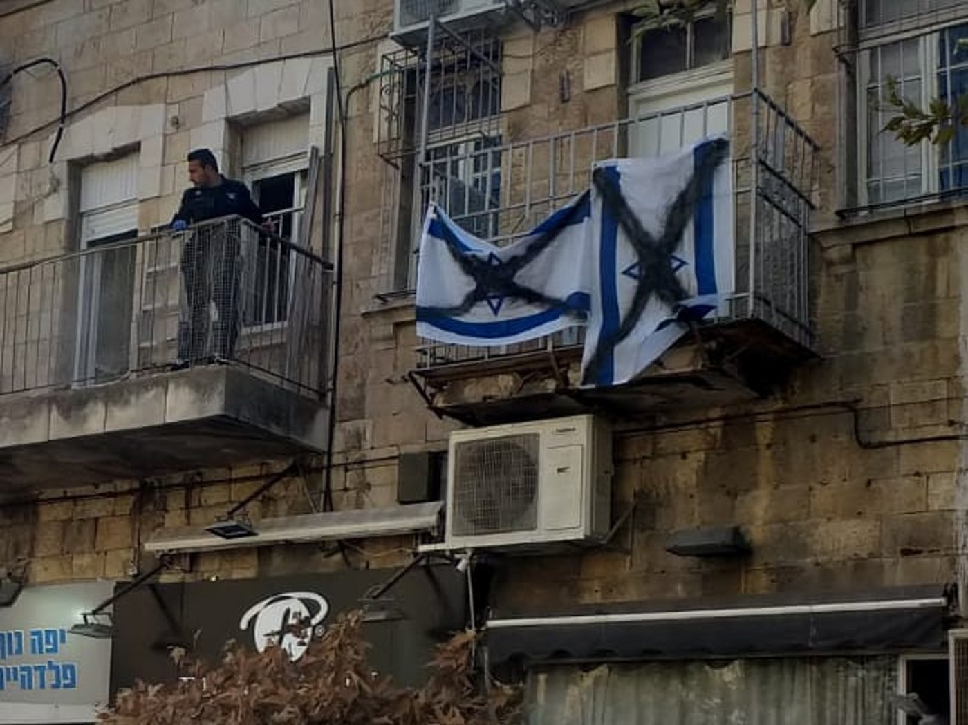 שוטרים קפצו מהמרפסת של השכן והסירו דגלים מרוססים