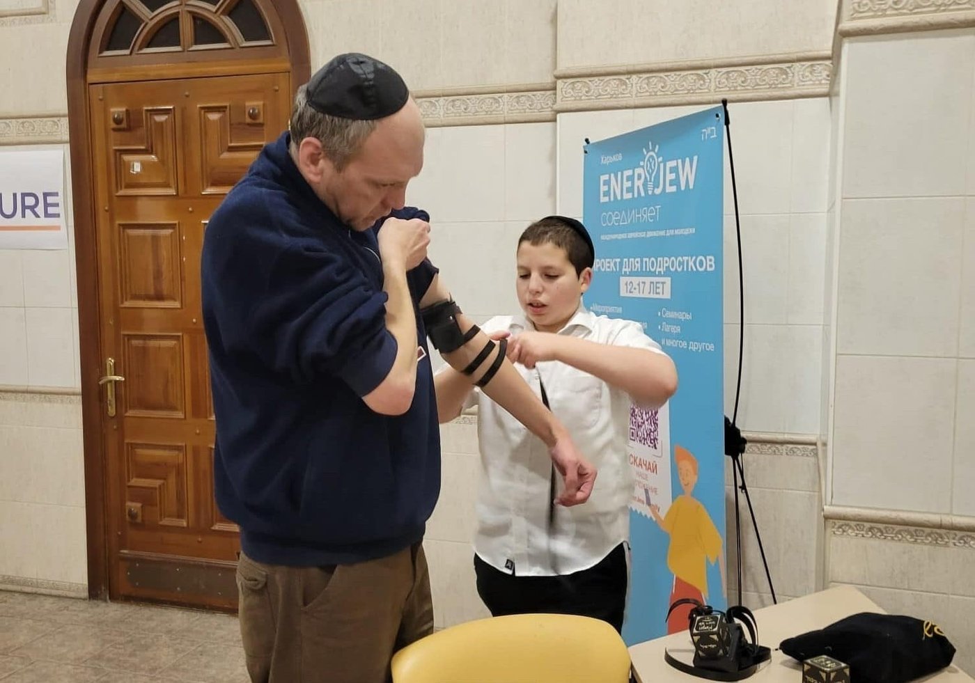 בנו של שליח חב"ד בחרקיב מניח תפילין ליהודי מקומי, השבוע