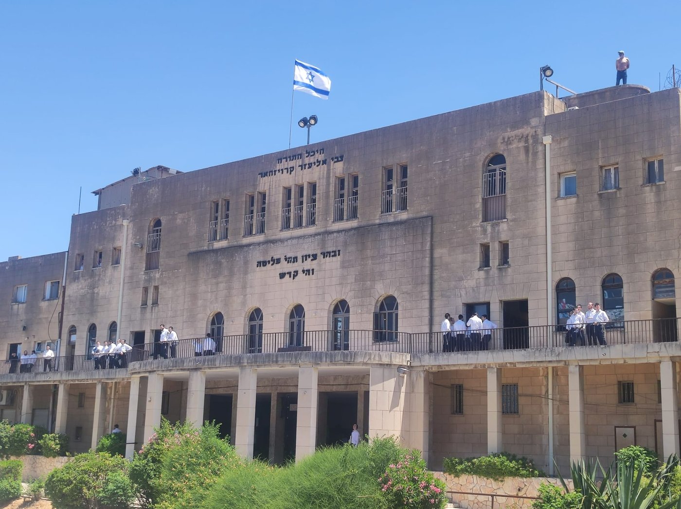 מאבטח מטעם ישיבת פוניבז' על גג הישיבה