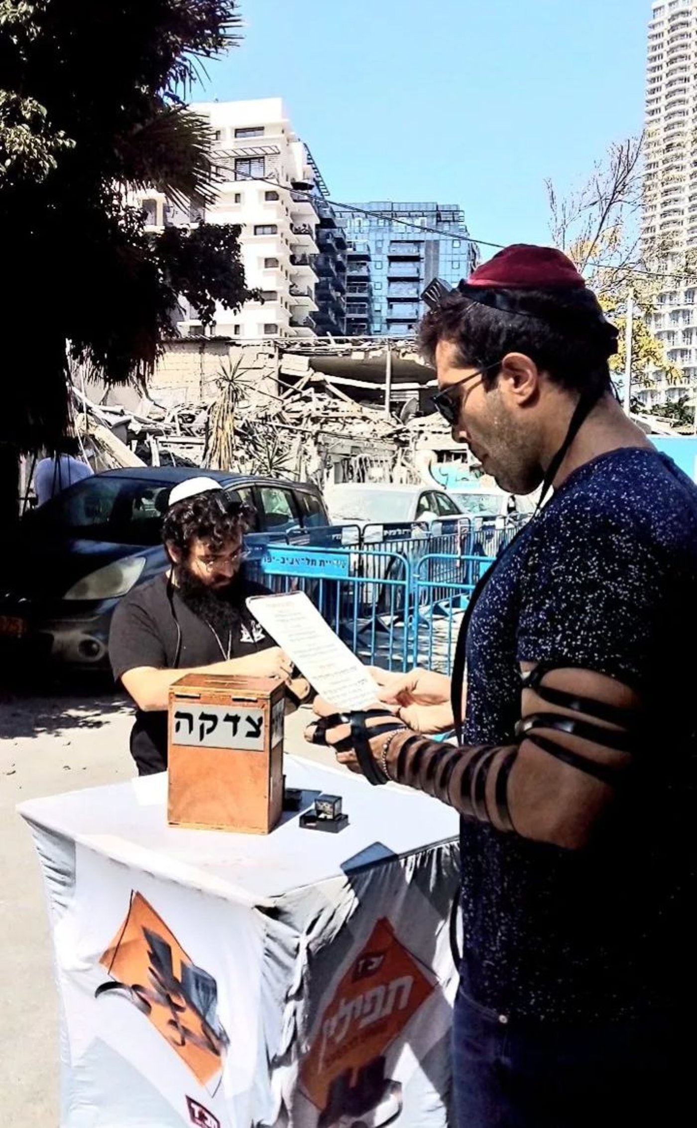 התעוררות בתל אביב: מניחים תפילין מול הבית שנפגע