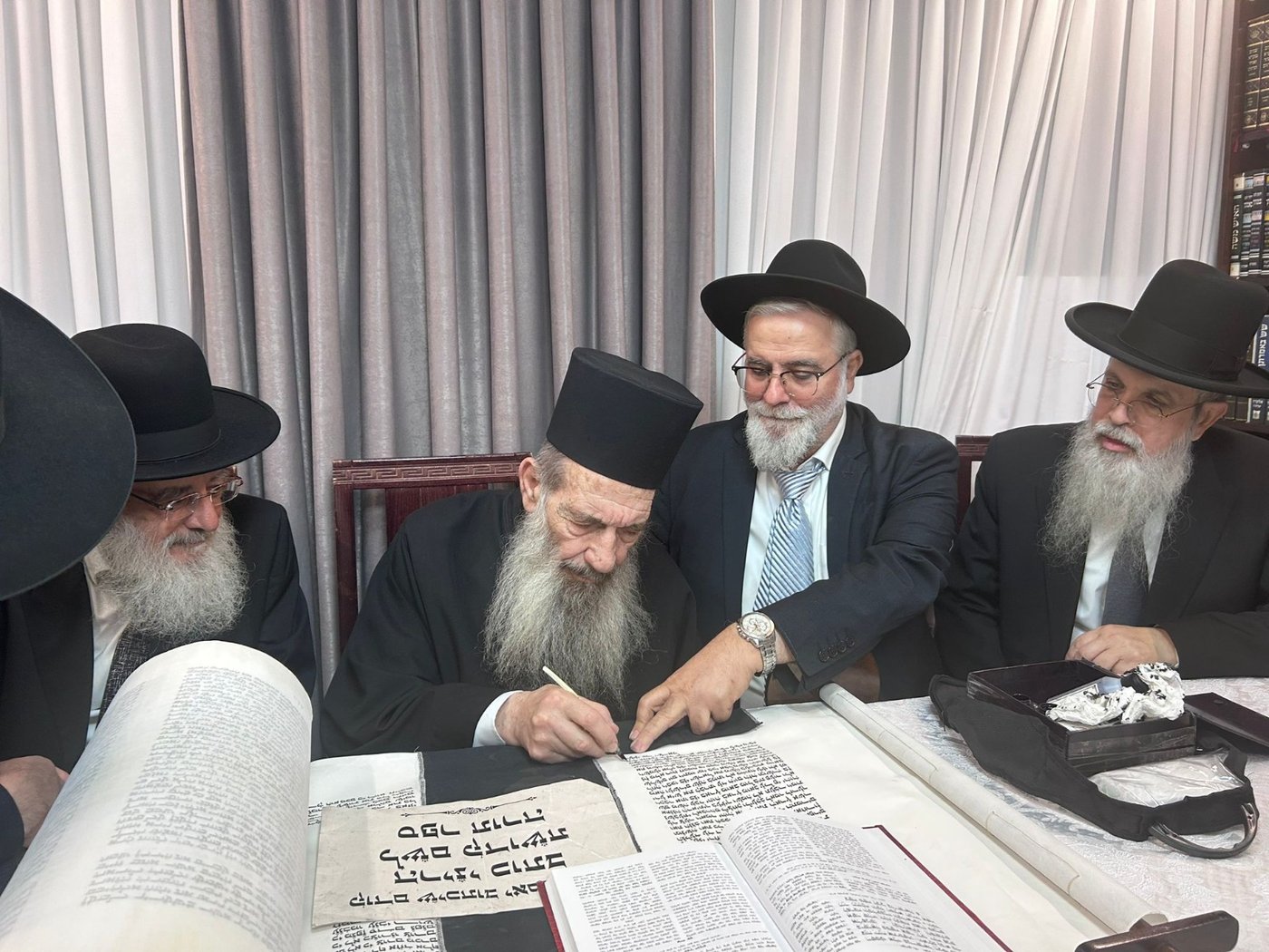 גדולי ישראל בכתיבת אות בספר התורה בביתו של הפוסק | תיעוד