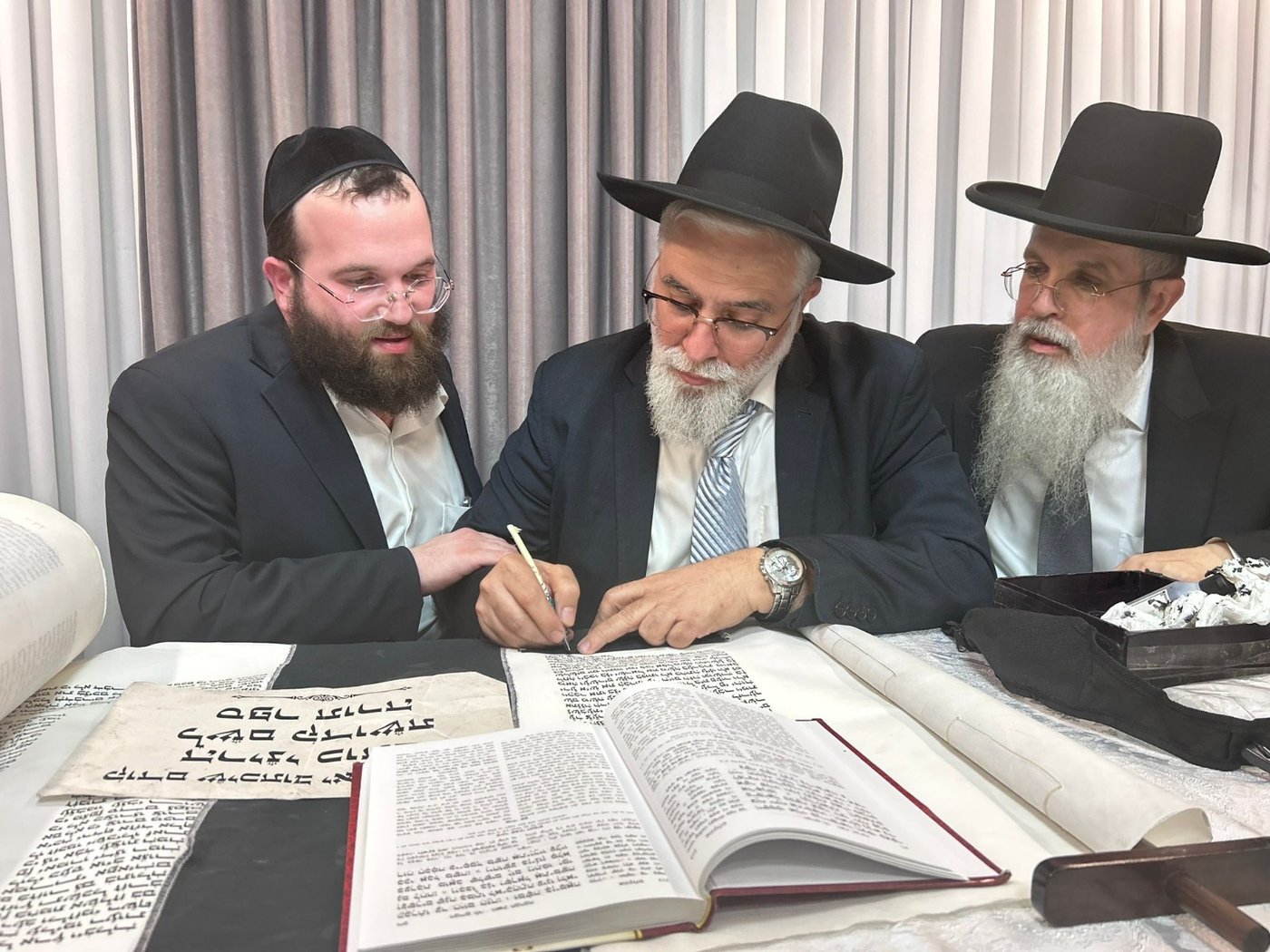 גדולי ישראל בכתיבת אות בספר התורה בביתו של הפוסק | תיעוד