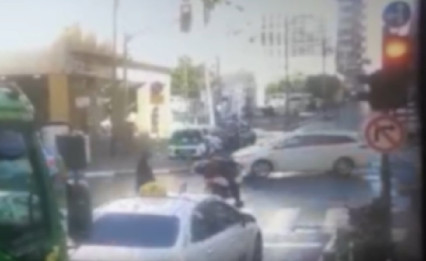 רוכב האופנוע חוצה באדום