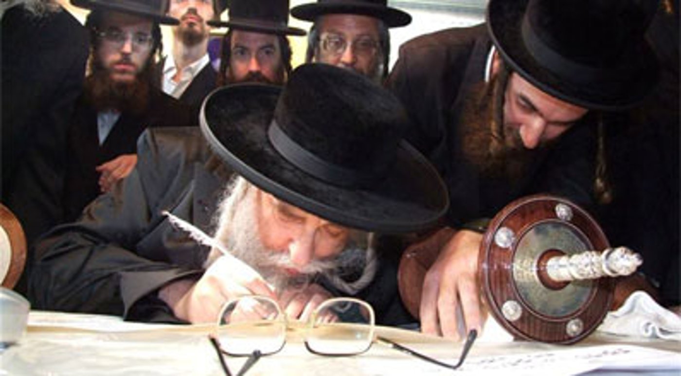 כותב אות בספר תורה.
