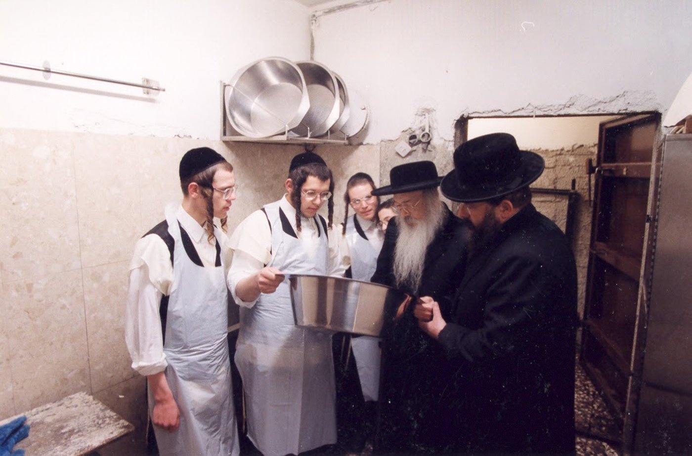 המנוח ז"ל משמש את מורו ורבו בהחזקת הקערה לפני אפיית המצות באחד השנים