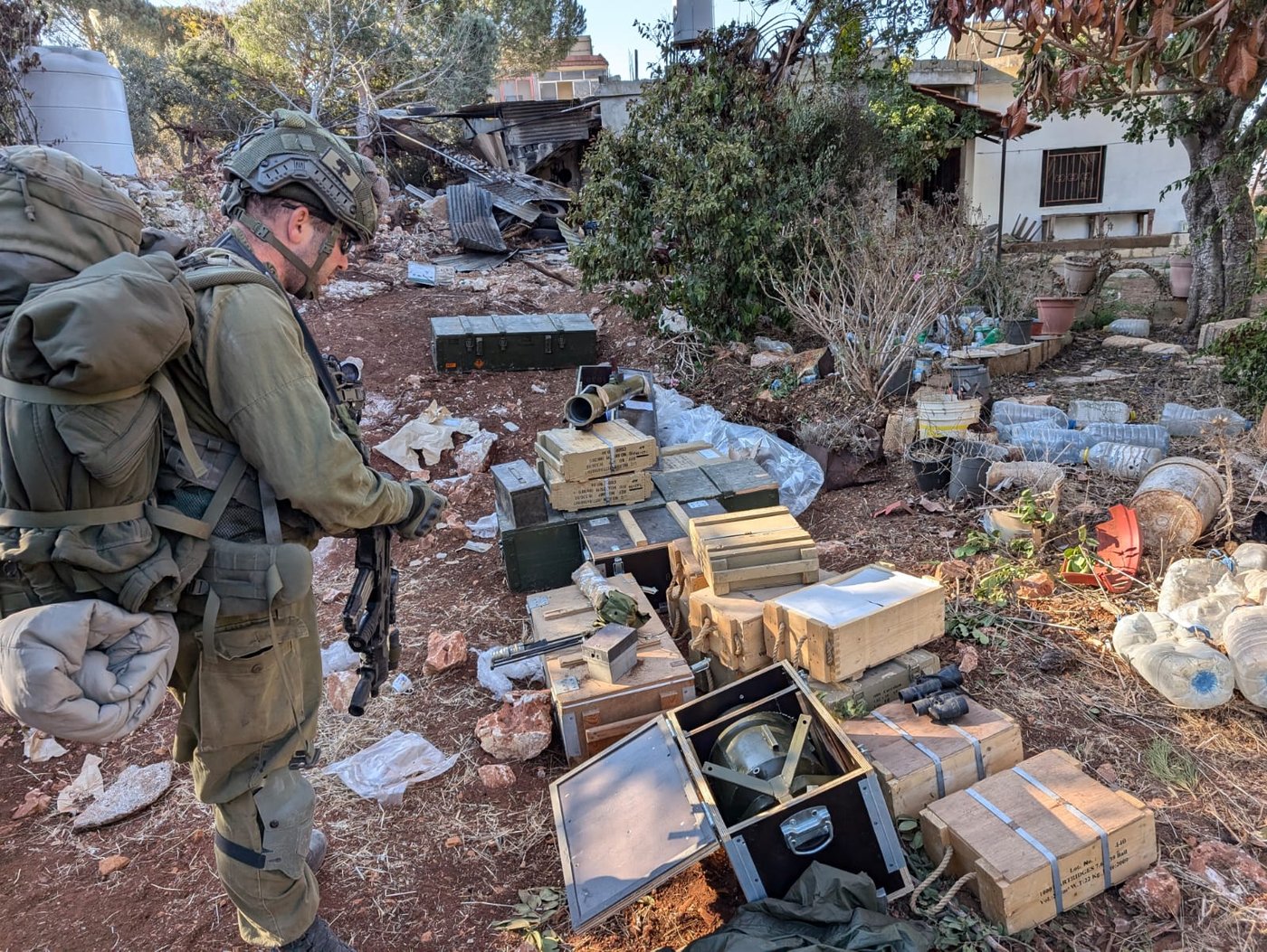 אחד הלוחמים עם חלק מציוד הלחימה שנמצאו בבתי החיזבאללה