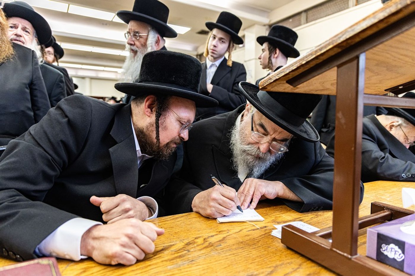 חסידי באבוב 45 נותנים קוויטלעך לרבם לפני המסע לצאנז