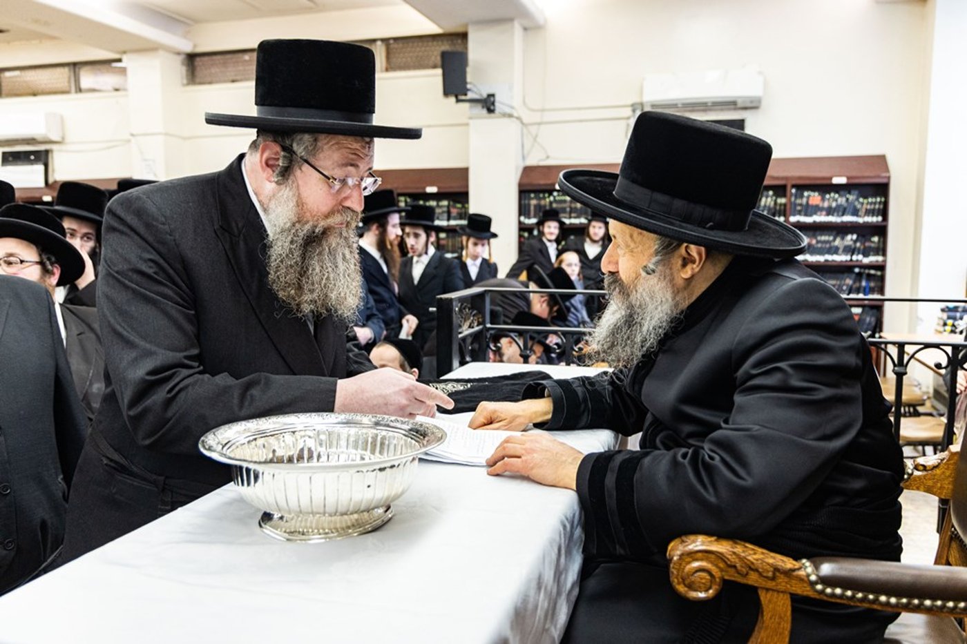 חסידי באבוב 45 נותנים קוויטלעך לרבם לפני המסע לצאנז