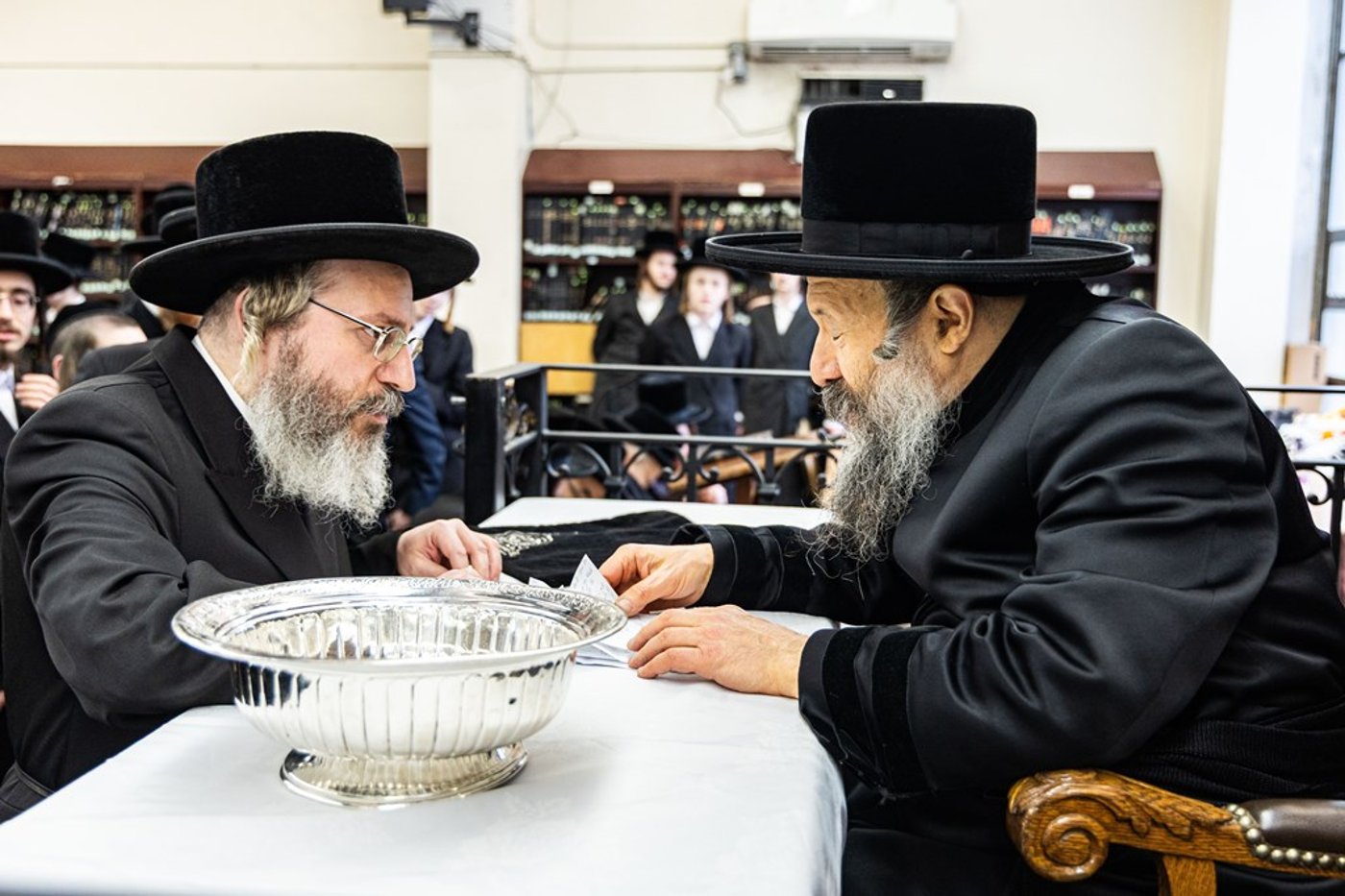 חסידי באבוב 45 נותנים קוויטלעך לרבם לפני המסע לצאנז