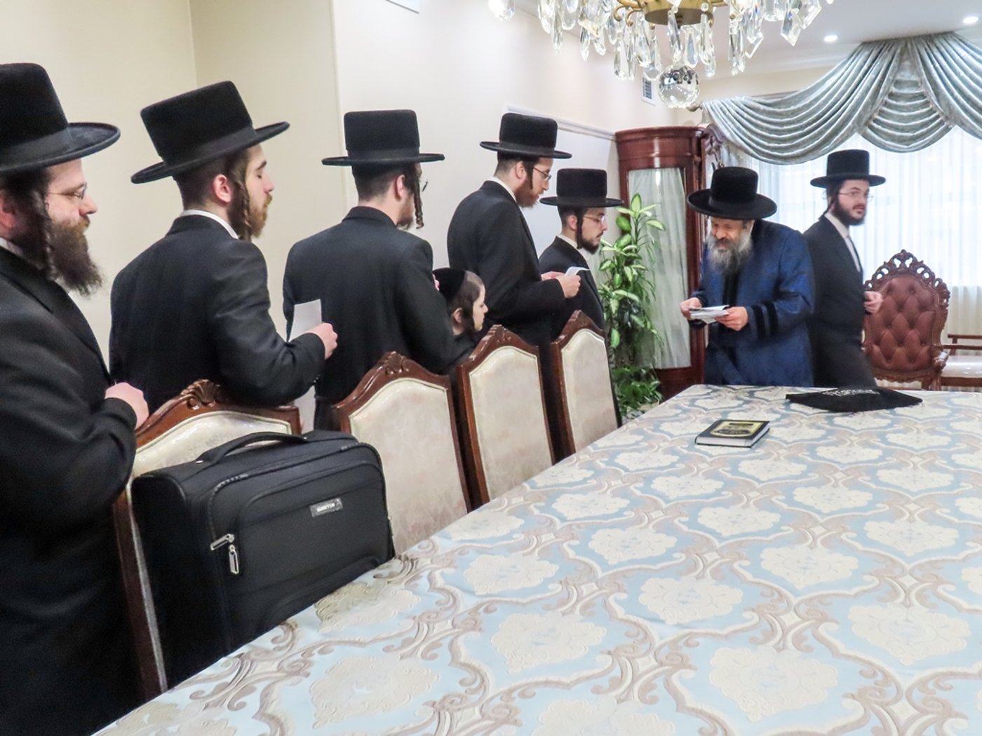 חסידי באבוב 45 נותנים קוויטלעך לרבם לפני המסע לצאנז