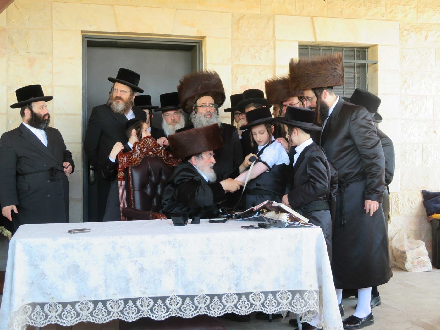 האדמו"ר מויז'ניץ בהנחת תפילין לניניו התאומים