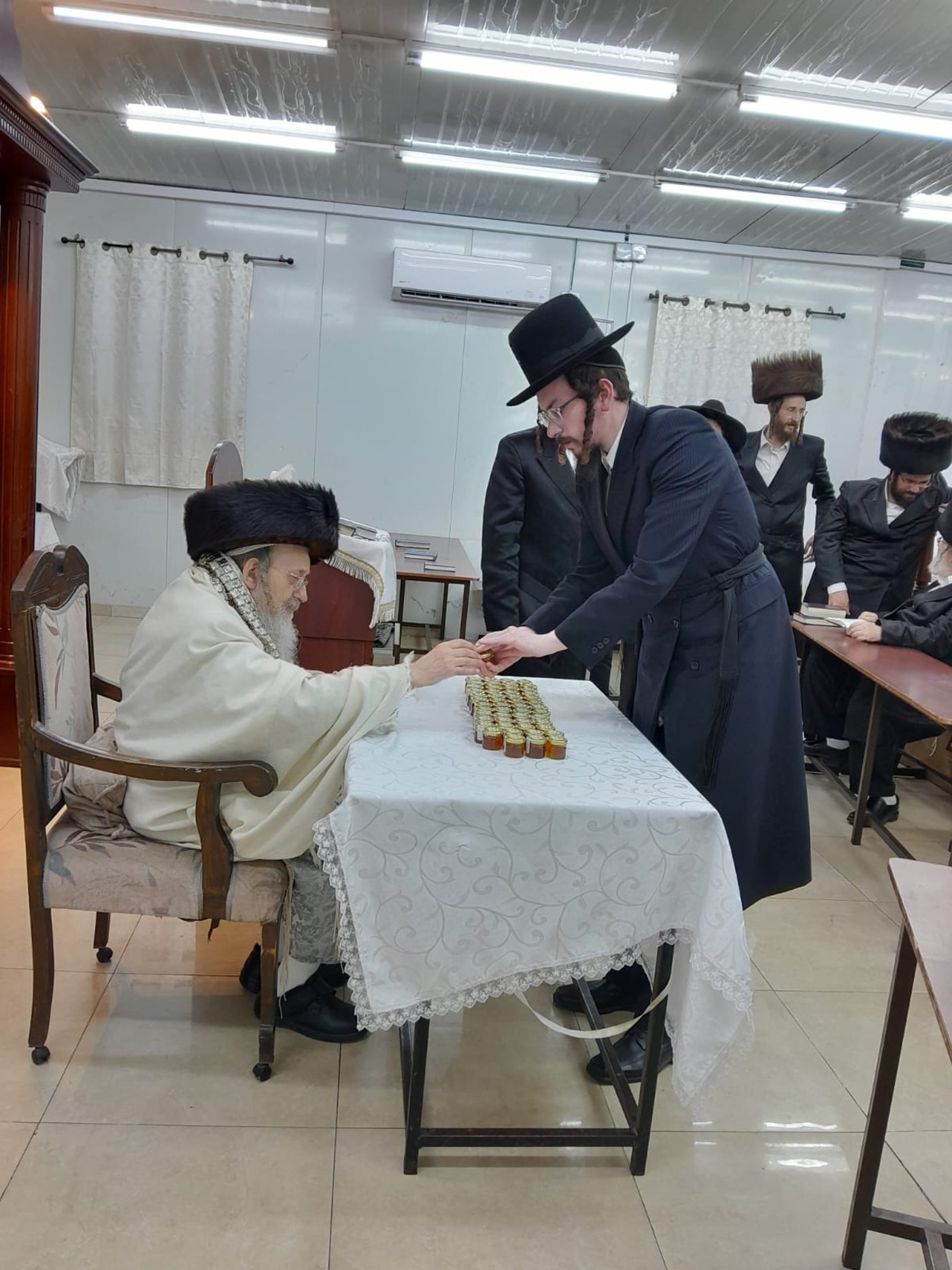 האדמו"ר מקאליש בחלוקת צנצנות דבש לאחר סליחות
