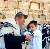 הרב הראשי מניח תפילין לנכדו 