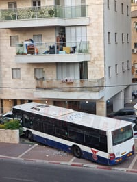 אוטובוס בחצר בנין בפ"ת בזמן האזעקות