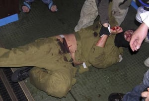 החייל המדמם נגרר, 'פעילי השלום' בידיים חשופות. התמונה לאחר שעברה עיבוד של סוכנות 'רויטרס'