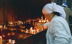 אישה מדליקה נרות בהר מירון