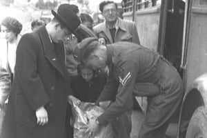 חייל בריטי עורך חיפוש במזוודותיהם של נוסעי אוטובוס לירושלים