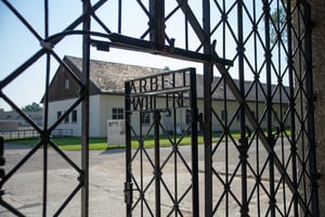 שער הכניסה למחנה דכאו. על הדלת רשומות המילים 'העבודה משחררת'
