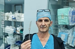 ד"ר כמאל חטיב מחזיק בידו את להב הסכין