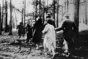 אישה מובלת ע"י גרמנים בתקופת השואה