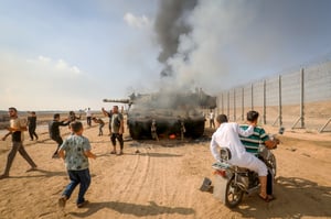 מחבלים בשטח ישראל לצד טנק ישראלי שנפגע במתקפה