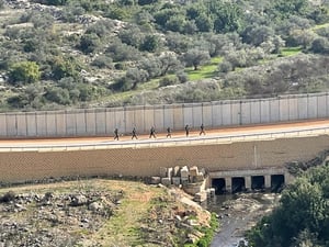 כוח הלל בדרך ליזומה בתוך הכפר הפלסטיני, עוברים בסמוך לתעלות הניקוז הפתוחות לרווחה