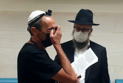 ליד החדר של בנו, הנאבק על חייו: אביו של בראל מניח תפילין לרפואתו
