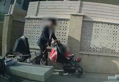 העגלה עם התינוק והאברך שממשיך בדרכו