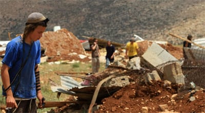 מתנחל על רקע בית הרוס,