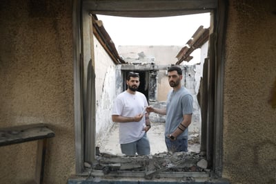 התאומים ברמן עם המזוזה ששרדה בבית השרוף