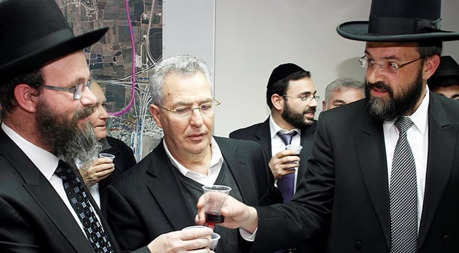מימין: הרב אטיאס והרב הלוי מרימים כוסית. בתווך: ראש-העיר
