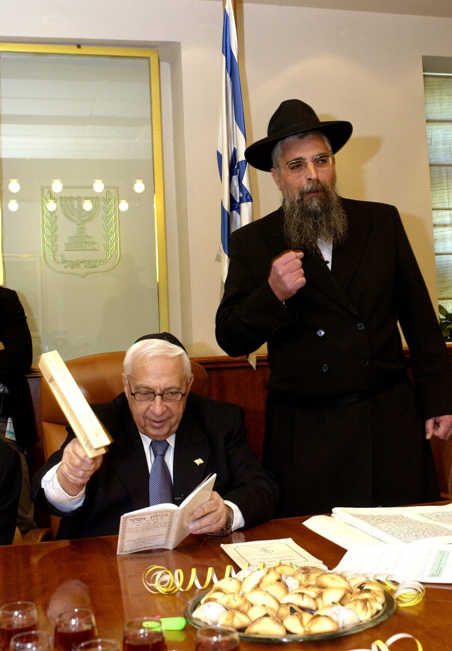 2004 - ראש הממשלה לשעבר אריאל שרון מרעיש ברעשן בקריאת שם "המן" בקריאת המגילה במשרד ראש הממשלה בירושלים