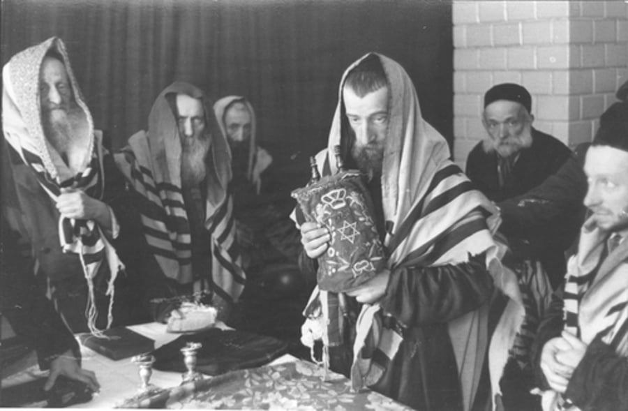תפילה בגטו, יהודים עטורי טלית סביב שולחן עם ספר תורה