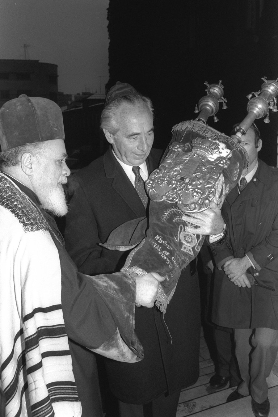 רה"מ פרס מחזיק בספר תורה שקיבל מהרב הראשי הרומני בבית הכנסת הגדול בבוקרשט ב-1985