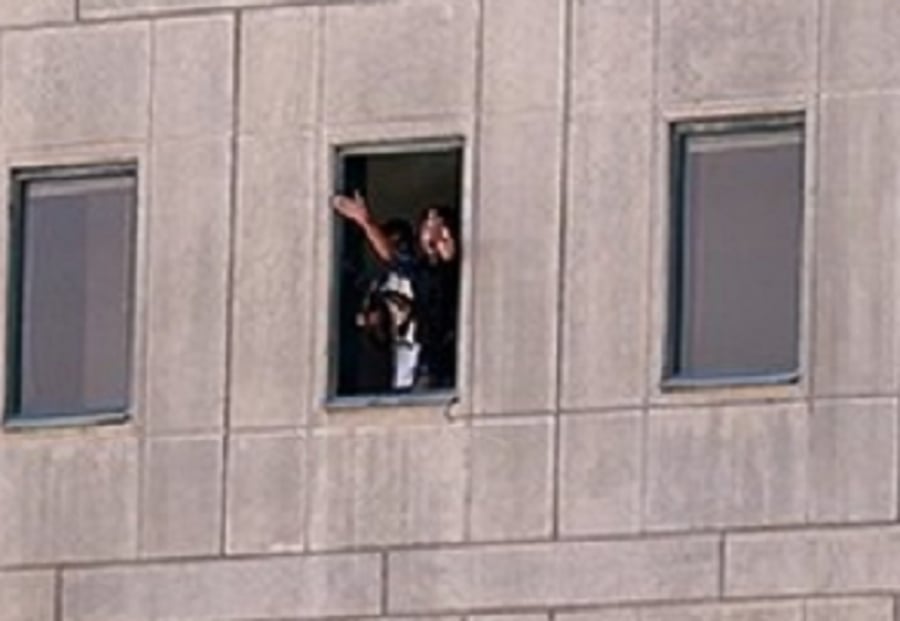 אחד המחבלים נראה מחלון הפרלמנט, מנופף כנראה בבן ערובה