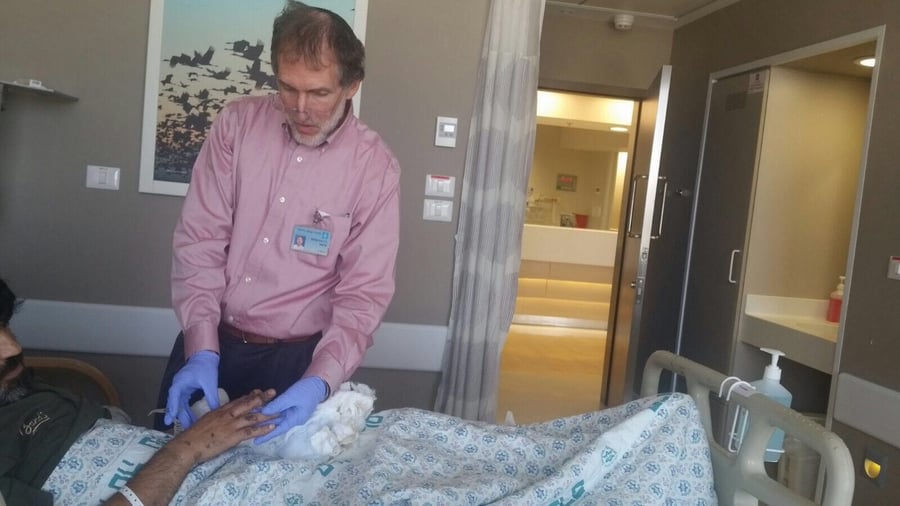 ד"ר מיכאל צ׳רנובסקי בודק את היד - לאחר הניתוח
