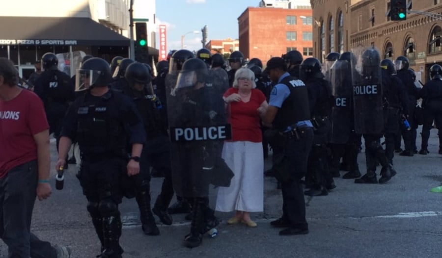 שוטרים עוצרים את אחת המפגינות
